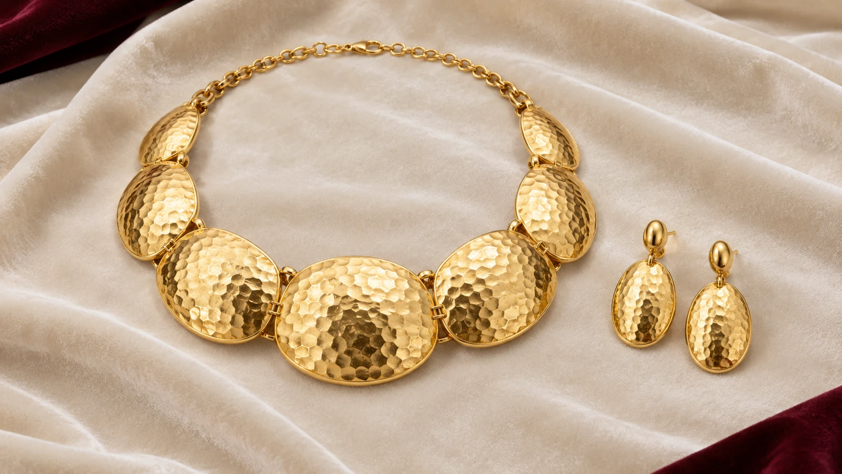 Gold in relief — complete gold set of broad convex hammered oval collar panels and two matching hammered oval earrings on ivory velvet