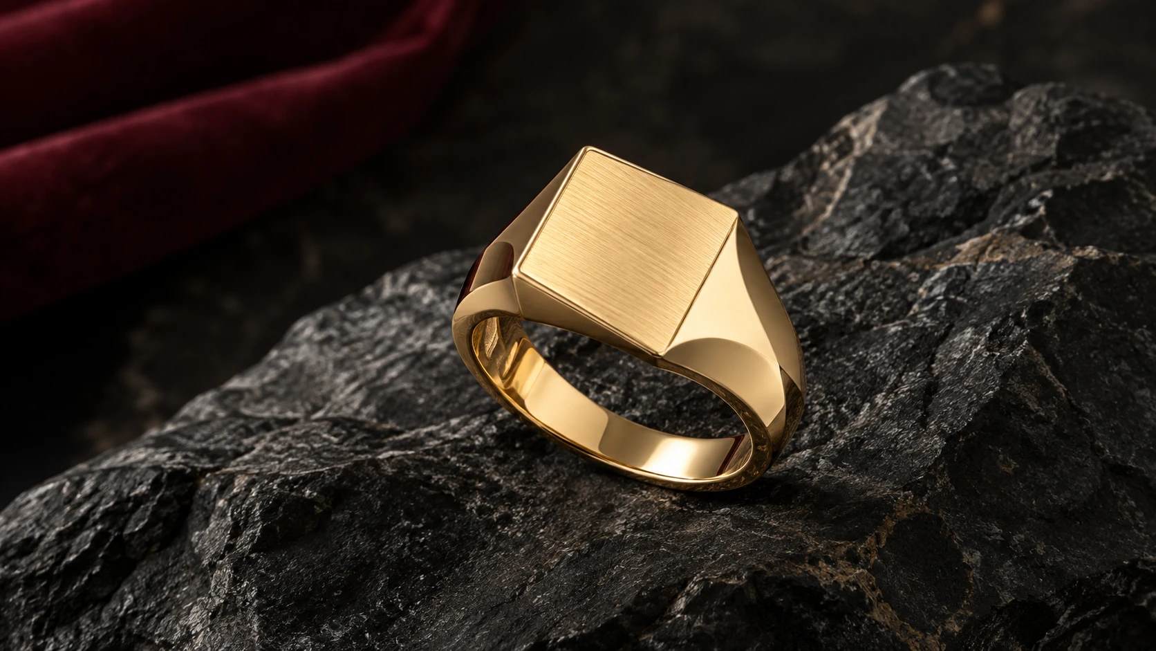 A ring in focus — one unique plain gold ring with raised oblique satin square top and polished beveled shank on black basalt