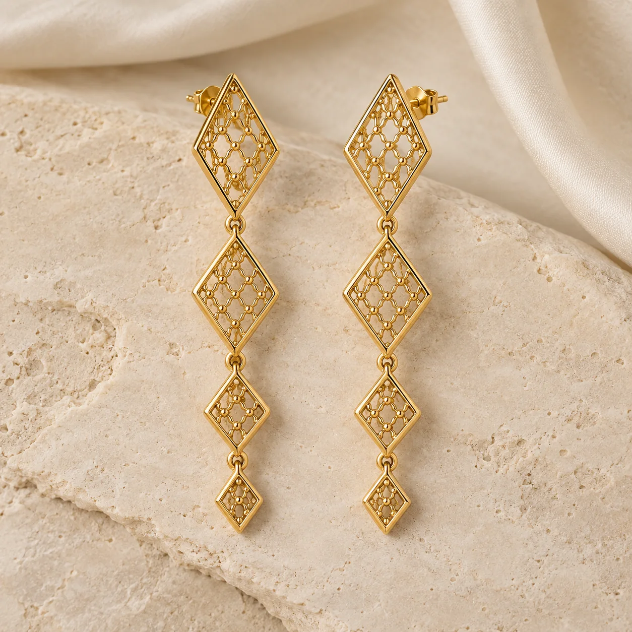 Earrings collection - one matched pair of yellow-gold articulated kite-shaped lattice drop earrings, four angular rhombus tiers getting smaller toward the bottom, secure posts