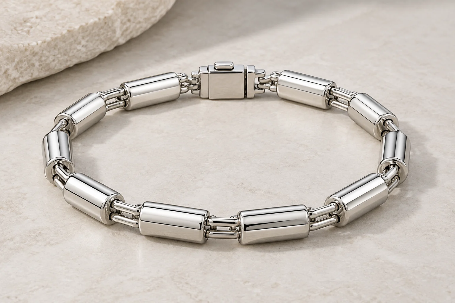 Silver Bracelets editorial - one polished silver bracelet of smooth alternating crosswise cylindrical roller links separated by pairs of short straight narrow connectors,.